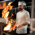 Koch mit feuer in der pfanne scaled e1742969554469.webp