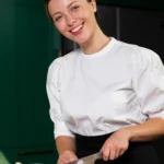 Laechelnde koechin schneidet zwiebeln scaled e1742969498522.webp