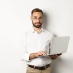 Mann in weiss mit laptop scaled e1742207312267.webp