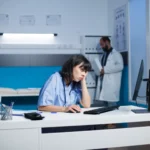 Nachdenkliche pflegerin vor dem pc scaled e1742207281159.webp